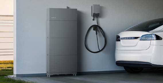 Home battery storage and EV charger installed in a garage beside an electric car
