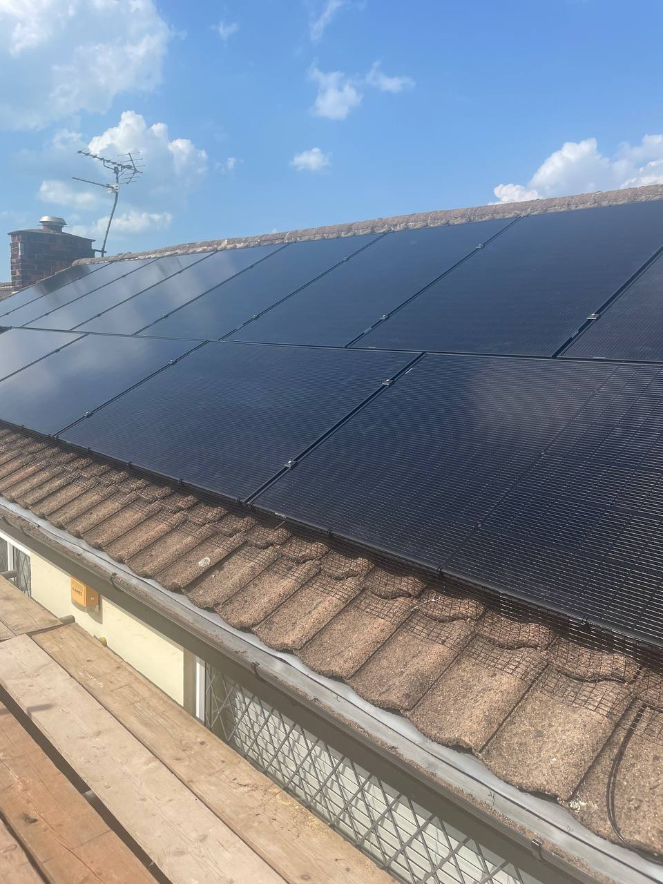 Close-up of black solar panels fitted to a tiled roof