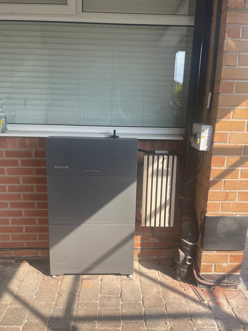 Outdoor EcoFlow battery storage unit beside brickwork