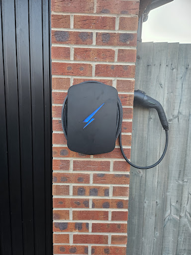 Tethered EV charger installed beside a driveway
