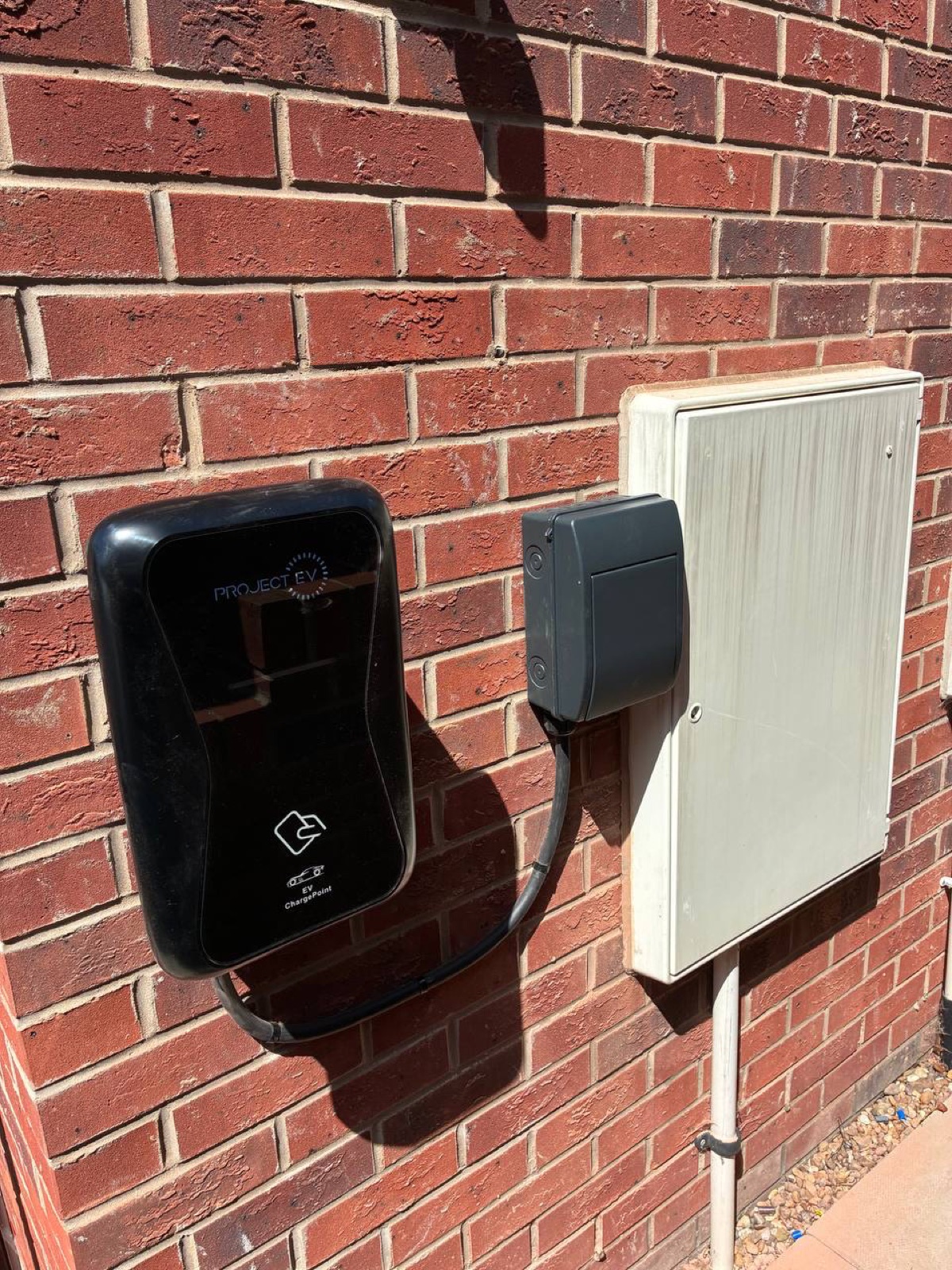 Zappi EV charger installed on a brick wall