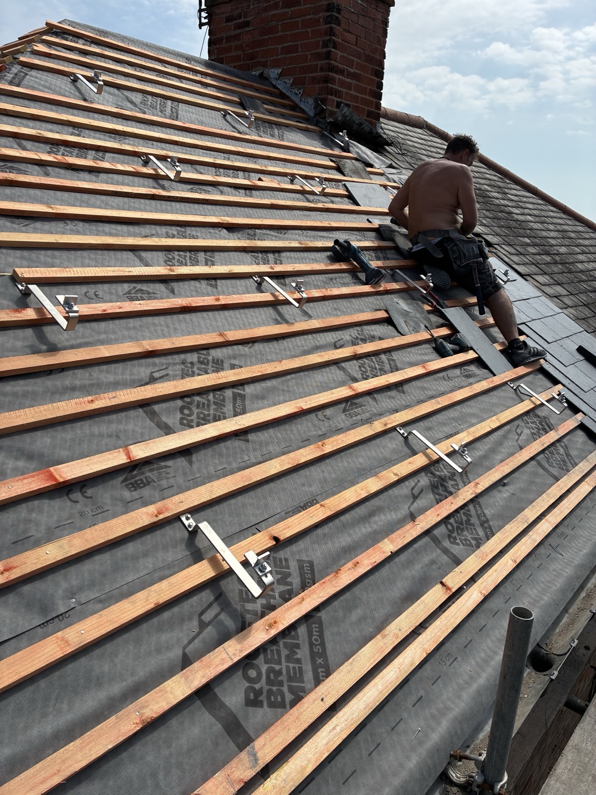 Clenergy solar mounting rails installed on roof battens during a new slate roof installation