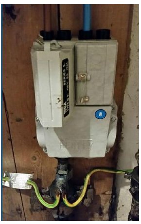 Real photograph of a modern grey UK electricity service cut-out